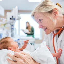 En lege som holder en baby